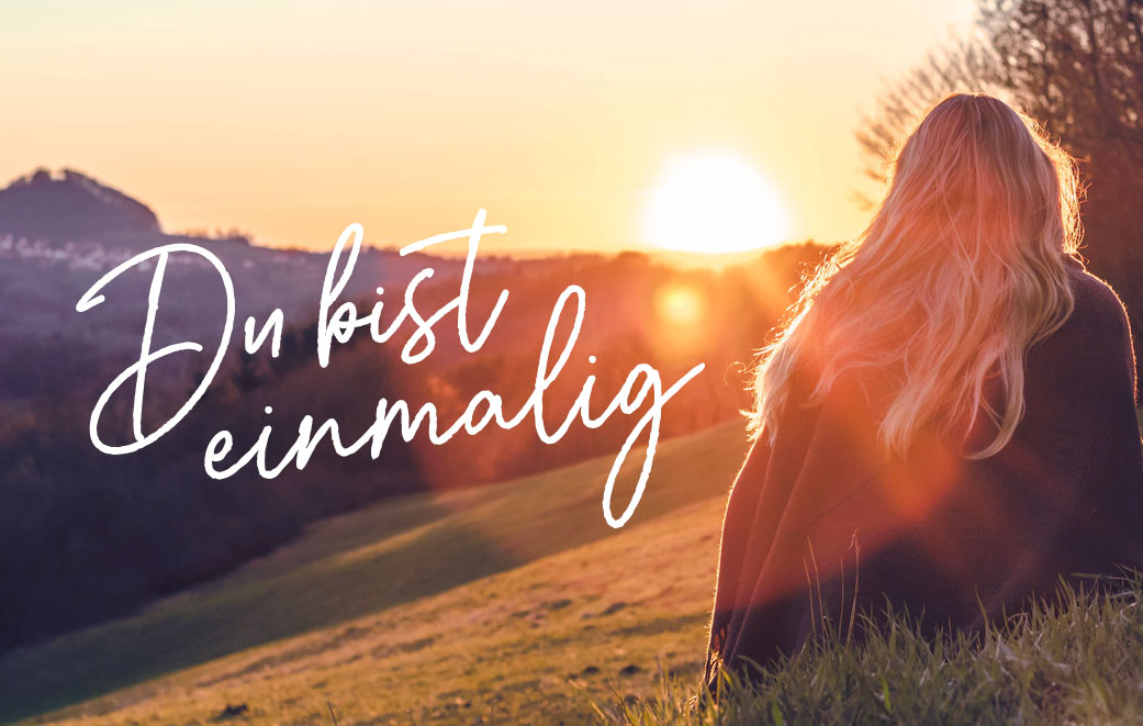 Frau steht im Sonnenaufgang. Blogbild zum Thema: Du bist einmalig
